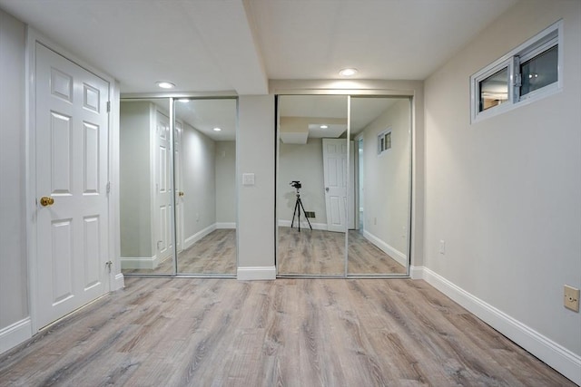 unfurnished bedroom featuring light hardwood / wood-style flooring and two closets