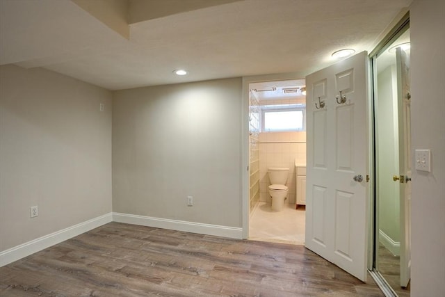 interior space featuring ensuite bathroom and light hardwood / wood-style flooring