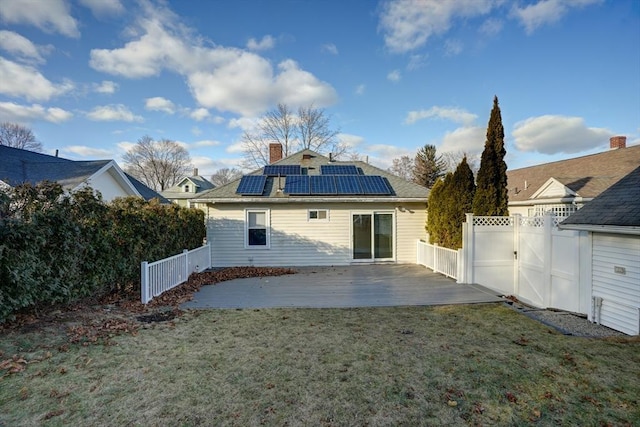 back of house featuring a lawn and solar panels