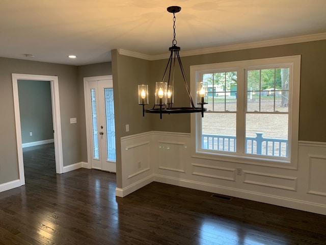 unfurnished dining area with an inviting chandelier, dark hardwood / wood-style floors, and ornamental molding