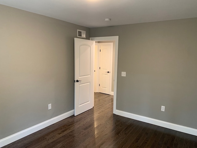 spare room with dark hardwood / wood-style floors