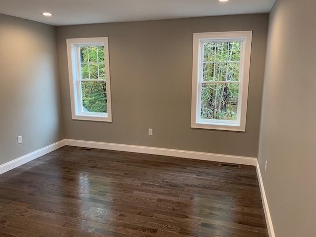 unfurnished room featuring dark hardwood / wood-style floors and a healthy amount of sunlight