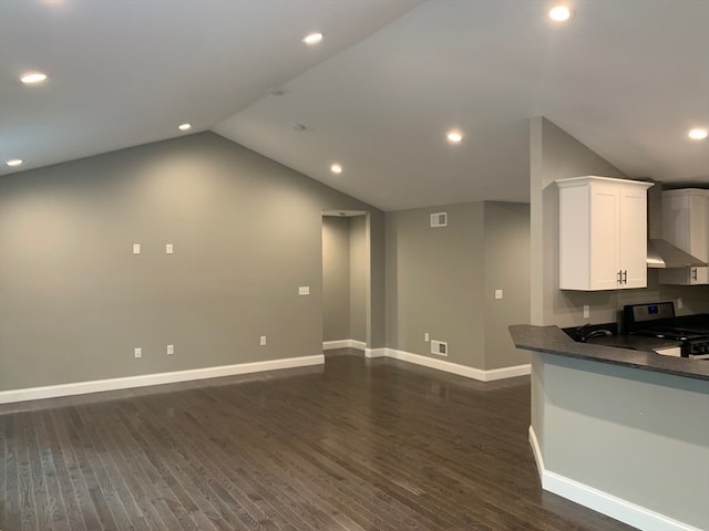 kitchen featuring dark wood-type flooring, kitchen peninsula, black / electric stove, vaulted ceiling, and white cabinetry