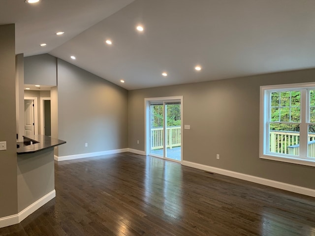 unfurnished living room with vaulted ceiling and dark hardwood / wood-style flooring