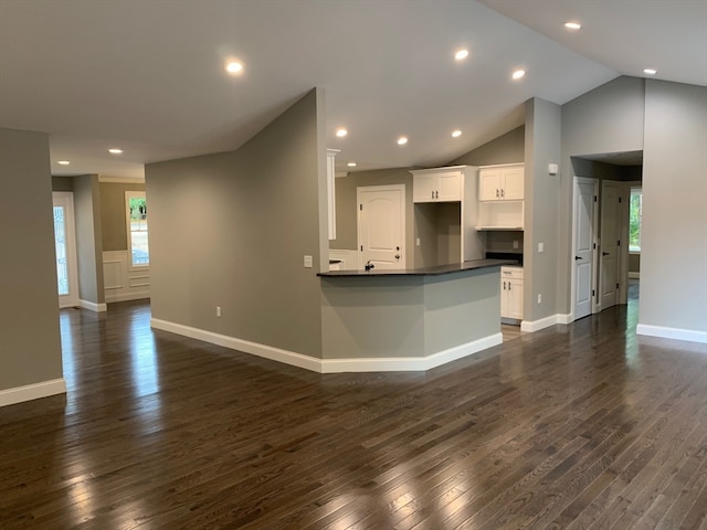 kitchen featuring kitchen peninsula, dark hardwood / wood-style floors, high vaulted ceiling, and white cabinetry