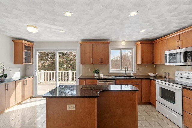 kitchen with light tile patterned floors, stainless steel appliances, a sink, and decorative backsplash