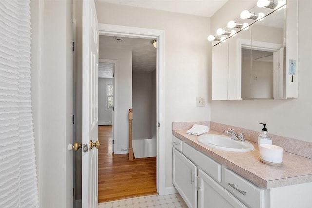 bathroom featuring baseboards, baseboard heating, and vanity