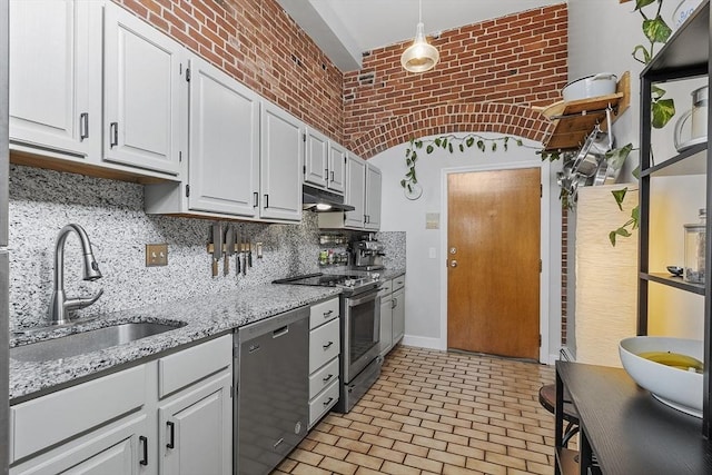 kitchen with white cabinets, appliances with stainless steel finishes, hanging light fixtures, under cabinet range hood, and a sink