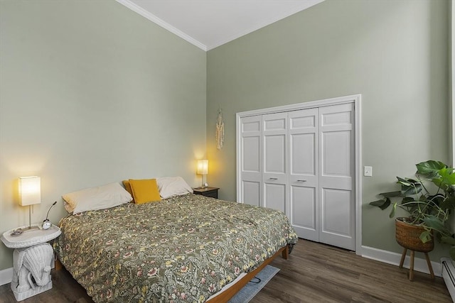 bedroom featuring baseboards, a baseboard radiator, dark wood-style flooring, crown molding, and a closet