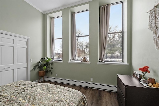 bedroom featuring a baseboard heating unit, dark wood-type flooring, and ornamental molding