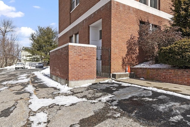 view of snow covered exterior with brick siding