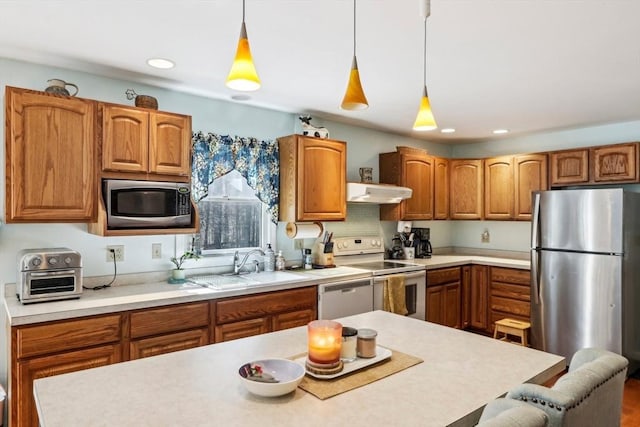 kitchen with a toaster, light countertops, under cabinet range hood, a sink, and stainless steel appliances