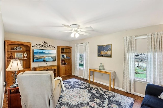 interior space featuring a ceiling fan, baseboards, and wood finished floors
