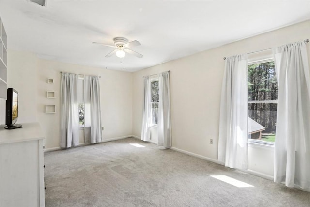 spare room with baseboards, a ceiling fan, and carpet flooring