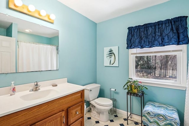 bathroom featuring baseboards, toilet, and vanity