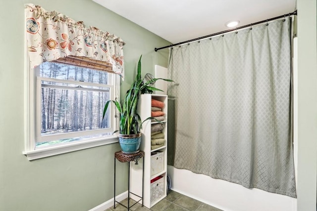bathroom with baseboards, tile patterned floors, and shower / tub combo