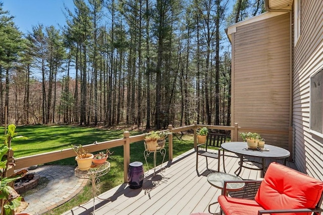 wooden deck featuring a yard and a forest view