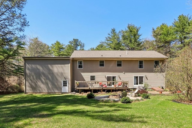 back of property featuring a lawn, an outdoor fire pit, and a deck