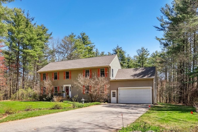 colonial-style house with an attached garage, concrete driveway, and a front yard