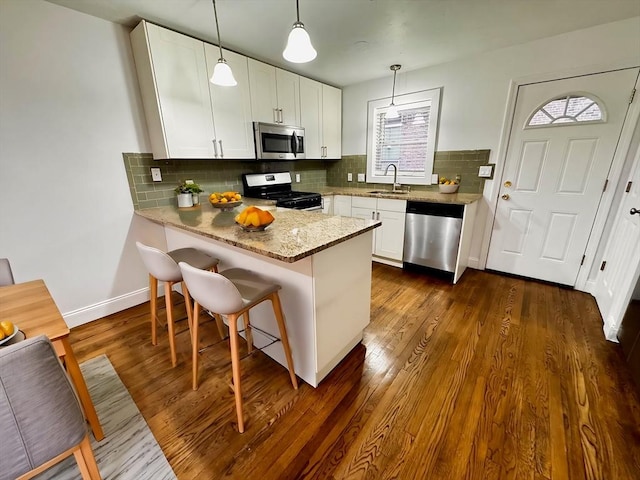122 W 7th St Unit B, Boston, MA 02127 - kitchen featuring appliances with stainless steel finishes, a sink, white cabinetry, and a peninsula