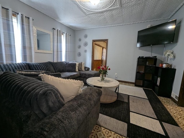 living room with a textured ceiling and baseboards