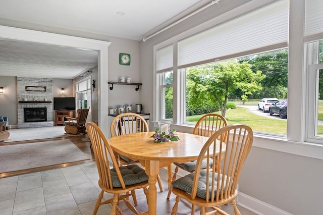 107 Washington St, Pembroke, MA 02359 - dining space with healthy amount of natural light, a brick fireplace, and light tile patterned floors