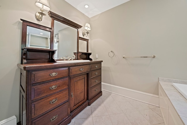 bathroom featuring tile patterned flooring, vanity, and tiled bath