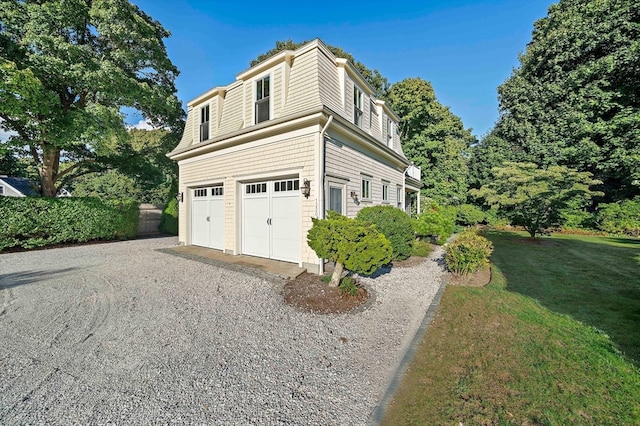 view of property exterior with a garage and a yard