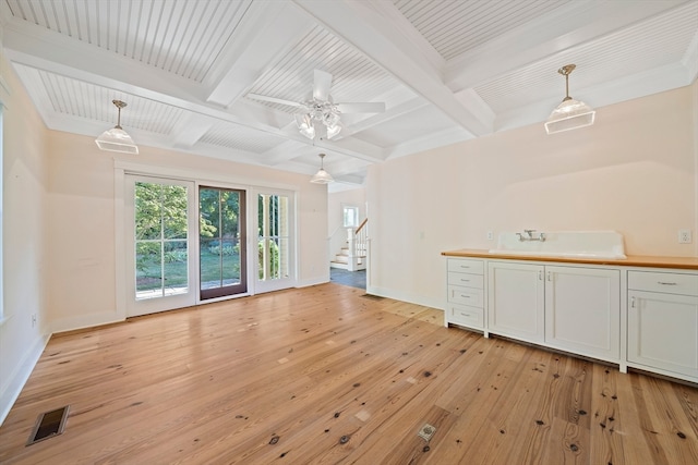 unfurnished living room featuring ceiling fan, beamed ceiling, and light hardwood / wood-style floors