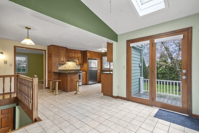 3 Norman Ave, Newburyport, MA 01950 - kitchen featuring freestanding refrigerator, dark countertops, a skylight, brown cabinetry, and backsplash