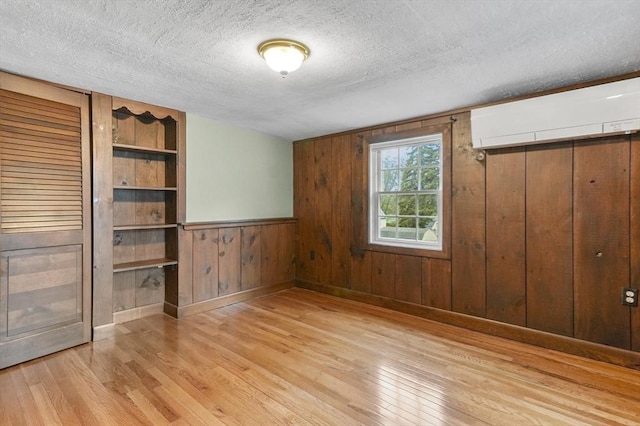 3 Norman Ave, Newburyport, MA 01950 - empty room featuring light wood-type flooring, a textured ceiling, wood walls, and baseboards