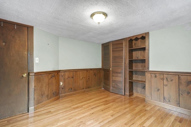 3 Norman Ave, Newburyport, MA 01950 - unfurnished room featuring a textured ceiling, wood finished floors, a wainscoted wall, and wooden walls