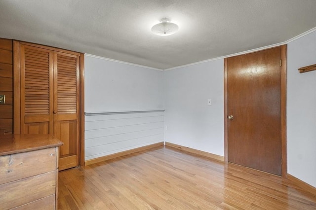 3 Norman Ave, Newburyport, MA 01950 - unfurnished bedroom with light wood-style floors, baseboards, crown molding, a textured ceiling, and a closet