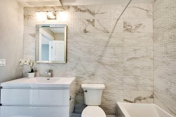 full bathroom featuring shower / bath combination, vanity, and toilet