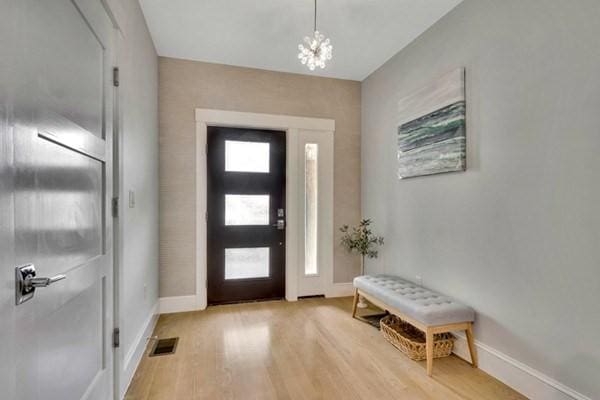 entryway with a chandelier and light wood-type flooring