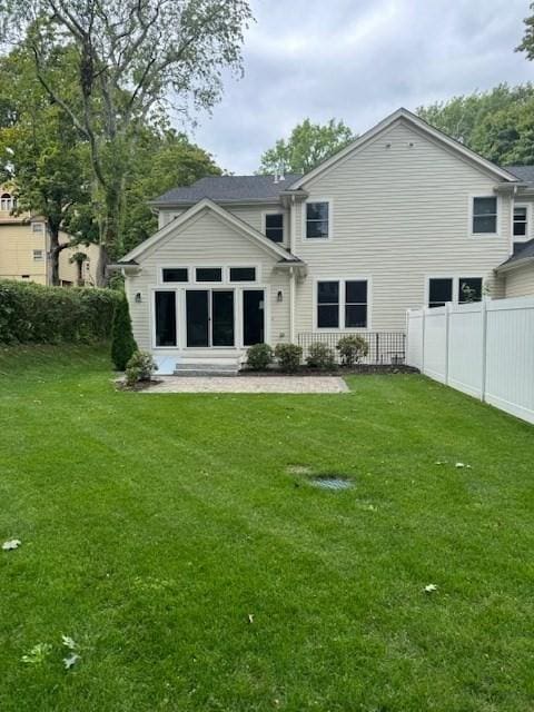 rear view of house featuring a lawn