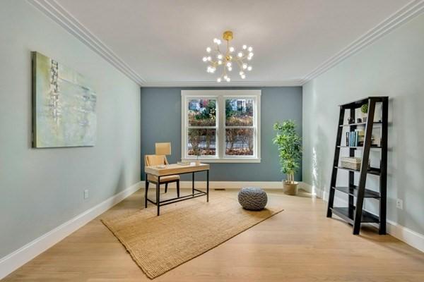 living area featuring an inviting chandelier, ornamental molding, and light hardwood / wood-style flooring