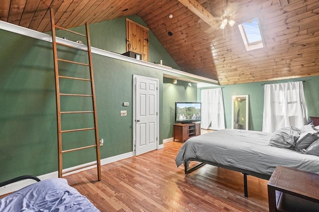 bedroom featuring ceiling fan, vaulted ceiling with skylight, wood ceiling, and hardwood / wood-style flooring