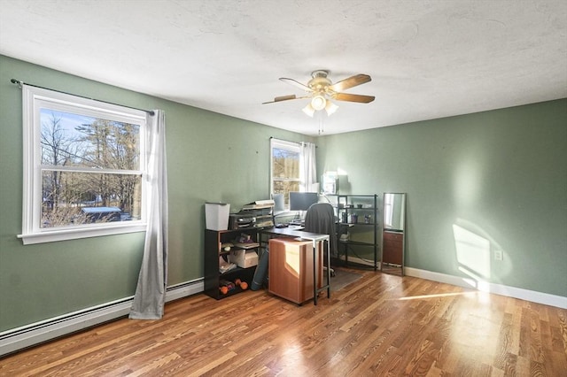 office area with baseboard heating, ceiling fan, and hardwood / wood-style floors