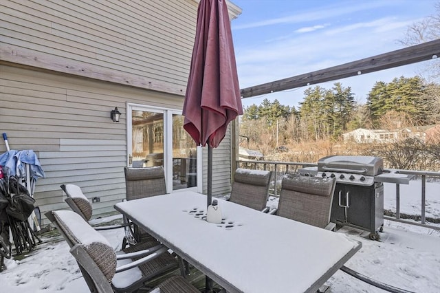 snow covered patio featuring a grill