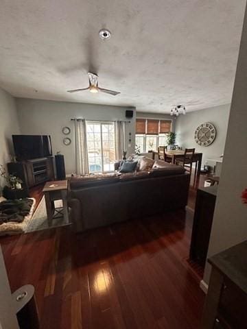 living room featuring ceiling fan and dark hardwood / wood-style flooring