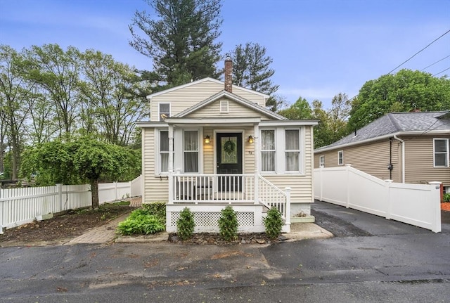 shotgun-style home with fence and a chimney