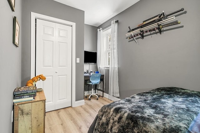 bedroom featuring light wood-style flooring, a desk, and baseboards