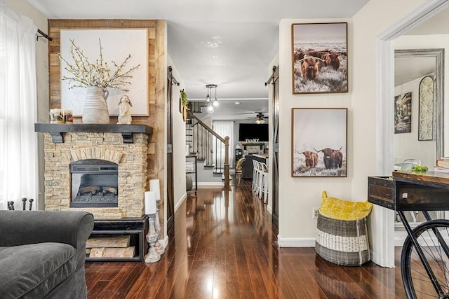 corridor featuring baseboards, hardwood / wood-style flooring, and stairs
