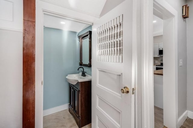 bathroom featuring tasteful backsplash, tile patterned flooring, lofted ceiling, and vanity