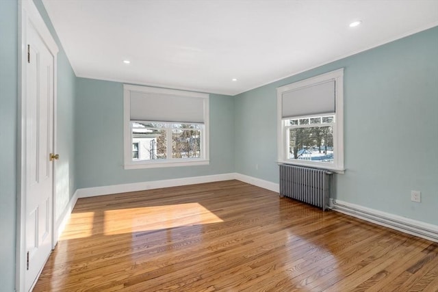 unfurnished room with light wood-type flooring and radiator