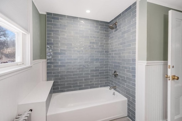 bathroom featuring tiled shower / bath combo and radiator