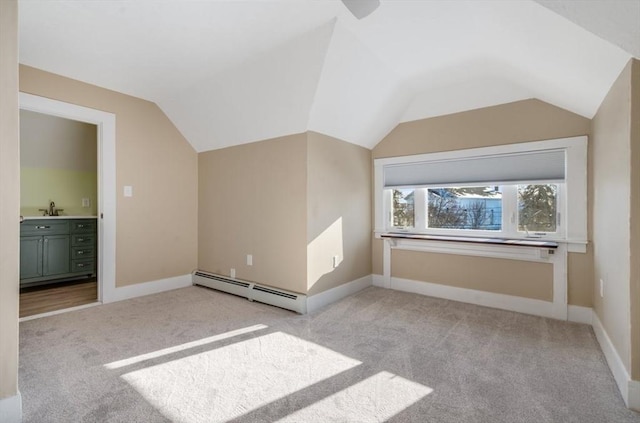 additional living space with a baseboard radiator, light colored carpet, and vaulted ceiling