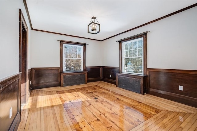 interior space featuring baseboard heating, light wood-type flooring, radiator, and ornamental molding