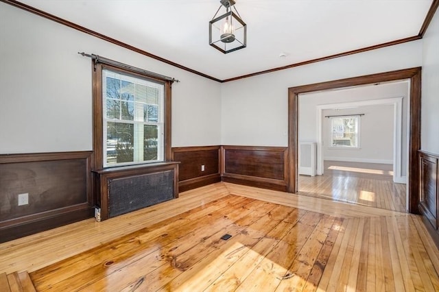 unfurnished room with hardwood / wood-style flooring and crown molding